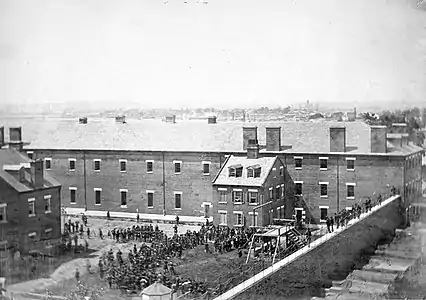 View of the scaffold and hanging bodies of the Lincoln Assassination conspirators taken from roof of the arsenal
