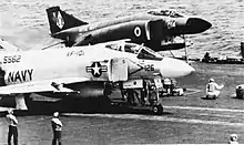 A Fleet Air Arm F-4K Phantom (rear) on the catapult of USS Independence alongside one of the ship's own F-4J models