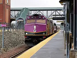 A diesel locomotive with a passenger train at a station