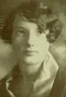 A young white woman with short curled hair