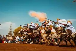 Fantasia exécutée à َAïn El Arbaa, dans la wilaya d'Aïn Témouchent, par un groupe de cavaliers photographiés au moment du tir de la salve de fusils.