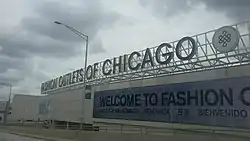 Fashion Outlets of Chicago mall with LED screens on the walls seen from Interstate 294