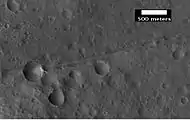 Close-up of a possible fault in Mare Acidalium, as seen by HiRISE under the HiWish program.  A circle is drawn around crater to show that it may be off round because of movement of the fault.  Many other faults are in the region.