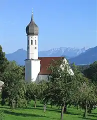 Kirche in Dettendorfim Hintergrund Kranzhorn (links) und Kaisergebirge