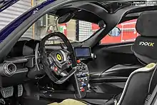 Picture of the cabin of a Ferrari FXX, where the launch control button can be seen in the middle of the center console