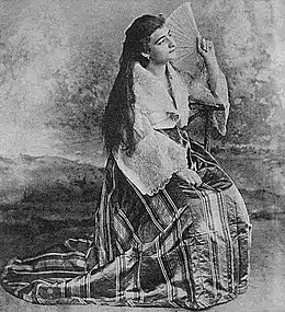 Woman in a traje de mestiza with a pañuelo and abanico folding fan (c. 1900)