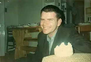  An informal and candid photograph of Finbarr Donnelly sitting in a kitchen, smiling broadly