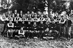 A group of young men with arms folded posing for a team photograph.