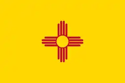 Flag of New Mexico(yellow flag, charged with a centered red Zia Pueblo sun symbol, colors of the Flag of Spain representing Hispano Nuevo México)