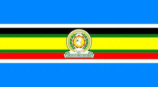 Nine horizontal strips coloured (from top to bottom): blue, white, black, green, yellow, green, red, white, then blue. The emblem of the EAC is placed in the centre.