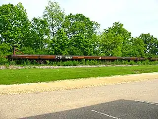 This Kansas City Southern Railway flatcar is fitted with fifth wheel couplings for hauling trailers. (2004)