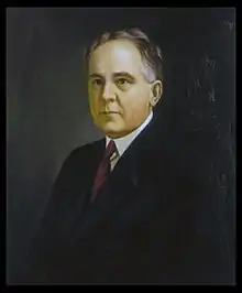 A color portrait of a man in his fifties wearing a suit