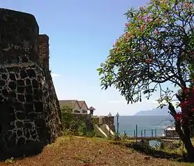 The walls of Fort Oranje with the island of Saba in the background