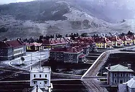 A group of buildings with trees and hills in background