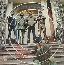 A photo of the band standing on stairs with concentric circles drawn on them