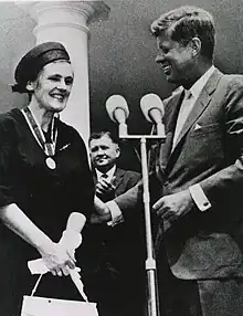 Black-and-white photo of a smiling Kelsey meeting with President John F. Kennedy; the medal for the President's Award for Distinguished Federal Civilian Service hangs around Kelsey's neck