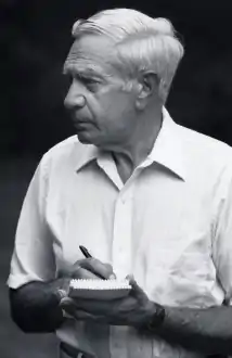 Photo of Rosa in 1991, wearing a white button-down shirt holding a pen and paper