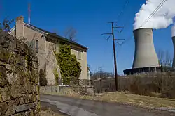 Abandoned house in the Fricks Locks Historic District, with the Limerick Generating Station (located in nearby Montgomery County) in the background