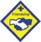 Diamond yellow and blue badge with two hands shaking: Friendship challenge