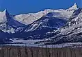 Dragons Tail seen from the east, with Fusillade Mountain far left edge, Reynolds Mountain upper right corner, and frozen Saint Mary Lake.