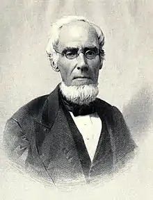 Painting of a middle-aged man with a bushy white beard, no sideburns, and a receding hairline.  He wears thin-framed glasses.  His suit jacket has wide lapels and is open over a vest and button-down shirt with bowtie.