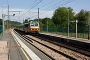 An express, pulled by BB 26028 passes through the station towards the south.