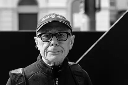 A portrait of Garth Evans in front of his sculpture on The Hayes, Cardiff City Centre, 2020.