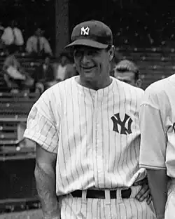 A smiling man in a dark cap and white pinstriped baseball uniform with an interlocked "N" and "Y" on the left breast.