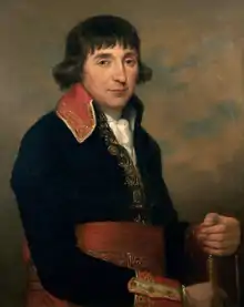 Painting of a man with long dark hair over his ears. He wears a dark blue French military uniform of the 1790s with a red sash around his waist.