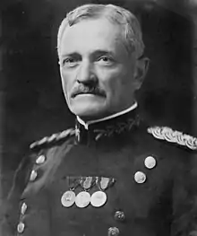 Man facing forward in uniform with two vertical columns of buttons with medals