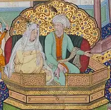 Detail of a painting displaying a woman wearing an off-white robe and a white headscarf, and a man wearing a red inner robe, a green outer robe, and a white turban, sitting on an ornate throne in front of a jewelled screen.