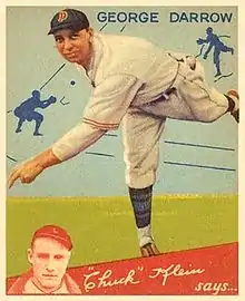 A man in a white baseball uniform and navy blue cap