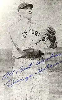 New York Yankees outfielder George Halas is pictured on a signed baseball card, waiting for the ball to land in his outstretched mitt.