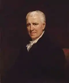 White haired white man in sober 18th-century clothes