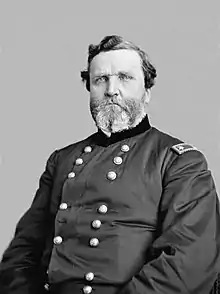 Black and white photo of a heavy-set, bearded man. He wears a dark military uniform with two rows of buttons and the two stars of a US major general on the shoulder tabs.