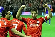 Gerrard celebrating with José Enrique and Luis Suárez in 2012