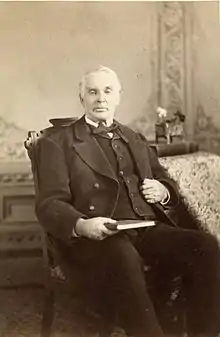 Photo of Elias Smith sitting in chair.