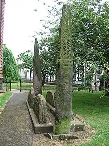 Image 58'Giants Grave', St. Andrew's churchyard, Penrith, an unusual arrangement of two Viking-age cross-shafts with four hogbacks (in the foreground). In addition, there is a smaller, Viking-age, wheel-headed cross just visible in the background (from History of Cumbria)