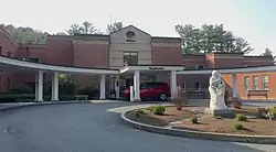 brick building with drive-up awning and a nice bench and sculpture out in front of it