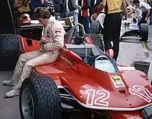 Gilles Villeneuve sitting beside the Ferrari 312T at the 1979 Dino Ferrari Grand Prix. Just like in previous seasons, the Scuderia Ferrari livery included Goodyear and Agip as their sponsors