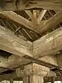 View showing that roof truss and mill are separate. Top set is roof truss; bottom set is beams supporting (hidden) main horizontal gear wheel of mill. Tie beam supporting top mill axle pivot is just visible between roof truss and mill