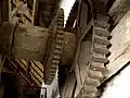 Inside threshing barn: gear wheels on end of drive shaft, where further gears and drive belts would be attached for driving various machines