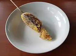 Four grilled bananas on wooden sticks