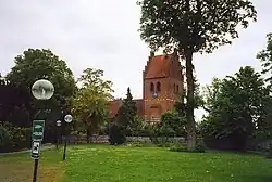 A redbrick church surrounded by trees