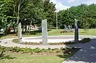 Sculture of dancing children and standing stone war memorial garden