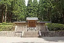 Wooden fence and gate among trees.