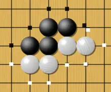 Image 3One black chain and two white chains, with their liberties marked with dots. Liberties are shared among all stones of a chain and can be counted. Here the black group has 5 liberties, while the two white chains have 4 liberties each. (from Go (game))