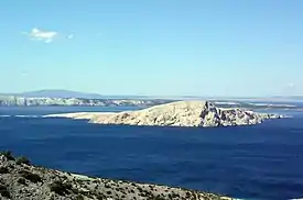 Photograph of a small rocky island at a short distance from the mainland shore