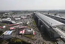 A large grandstand with market stalls behind it.