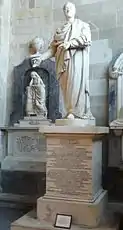 White stone statue of a man in a toga, in a stone building